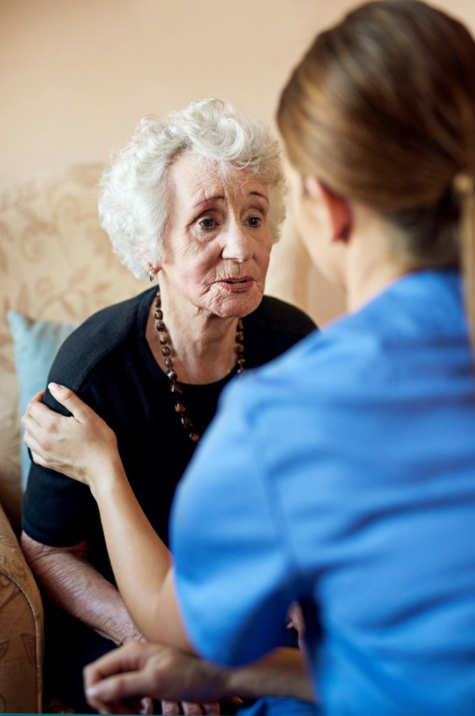 Shot of a nurse caring for an elderly woman at a nursing home